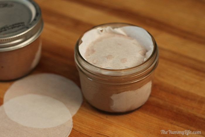 Parchment paper placed on top of frozen ice cream in individual containers for freshness