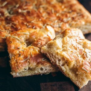 A square of gluten-free focaccia bread, showcasing its airy texture and golden-brown crust.