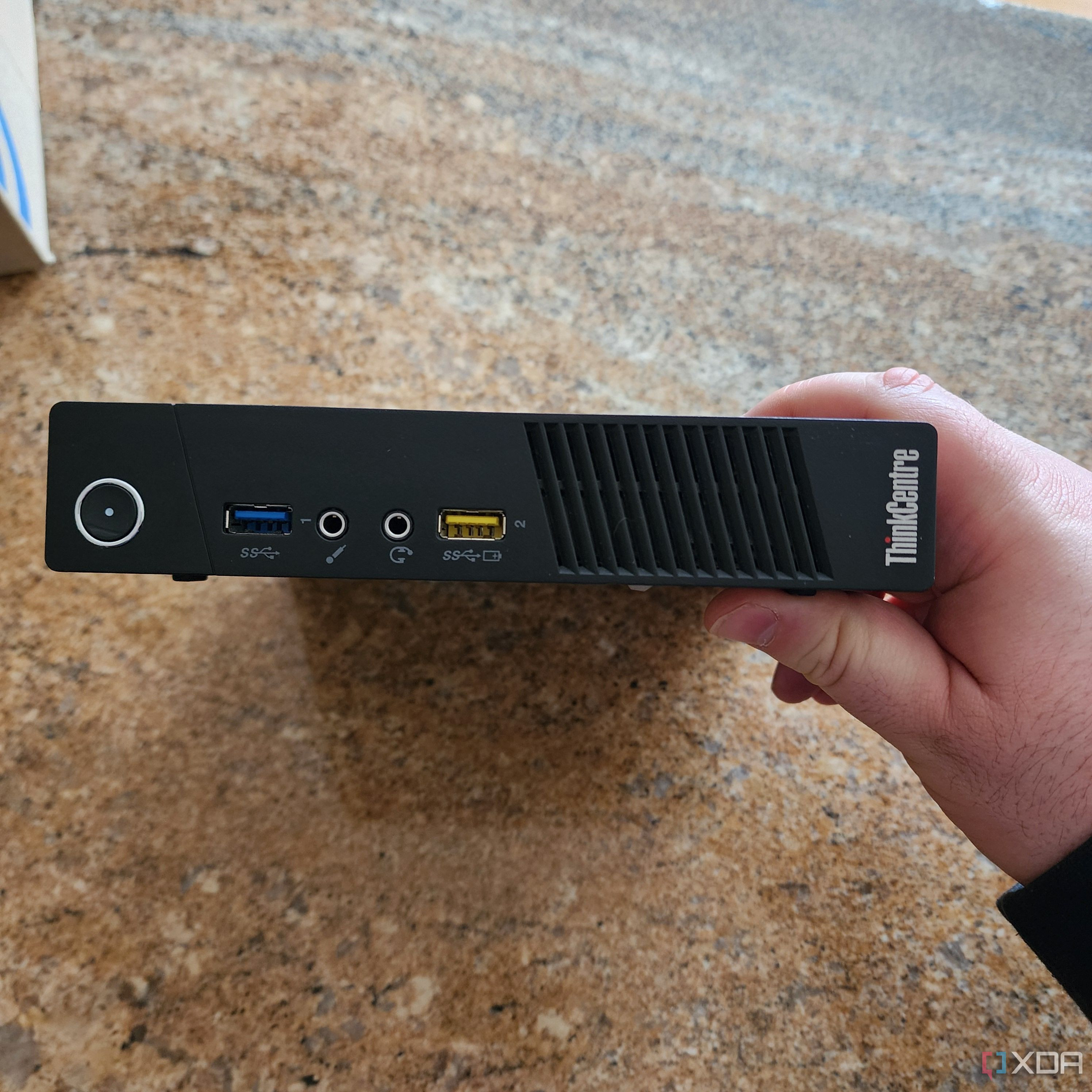 The front panel of a Lenovo mini PC, highlighting its compact design.