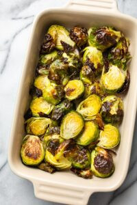 Crispy roasted Brussels sprouts with a sprinkle of herbs, showcasing their golden-brown color and appealing texture.