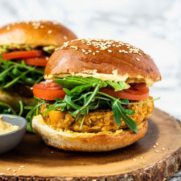 Butternut squash burgers on a wooden platter.