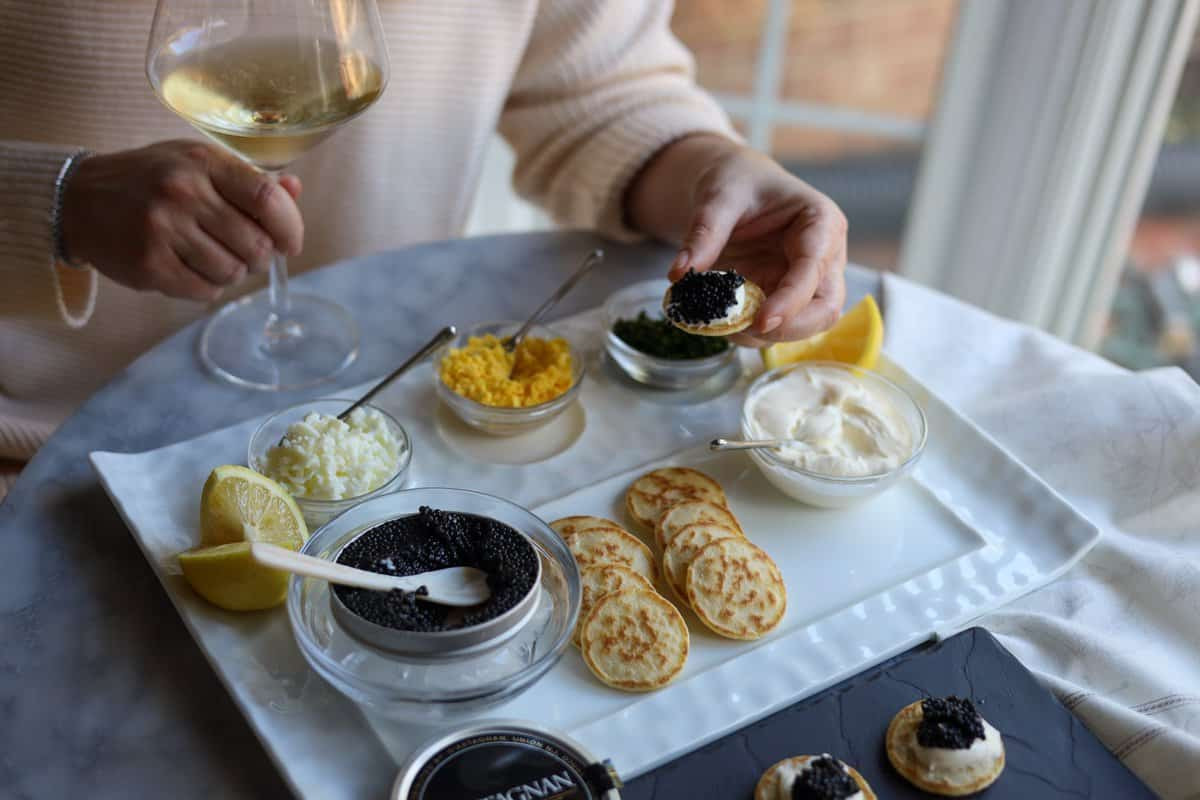 Serving caviar with blinis and creme fraiche