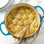 Chicken and Dumplings in a white bowl garnished with parsley.