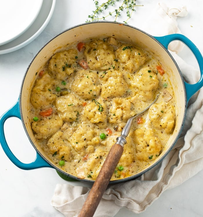 Chicken and Dumplings in a white bowl garnished with parsley.