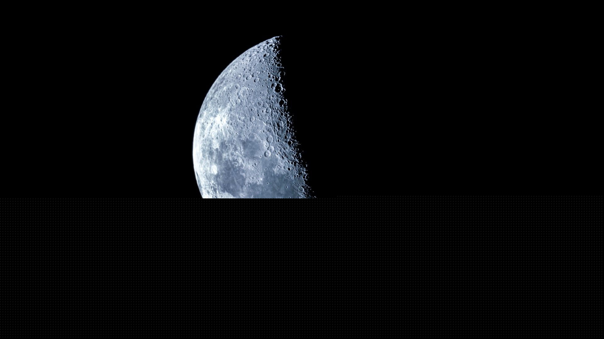 a half-lit moon in the night sky