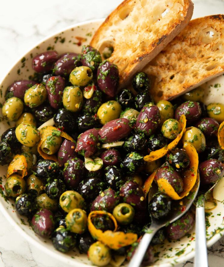 Close-up shot of a variety of olives in a bowl, showcasing different colors and sizes