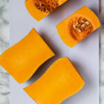 Butternut squash pieces on a cutting board.