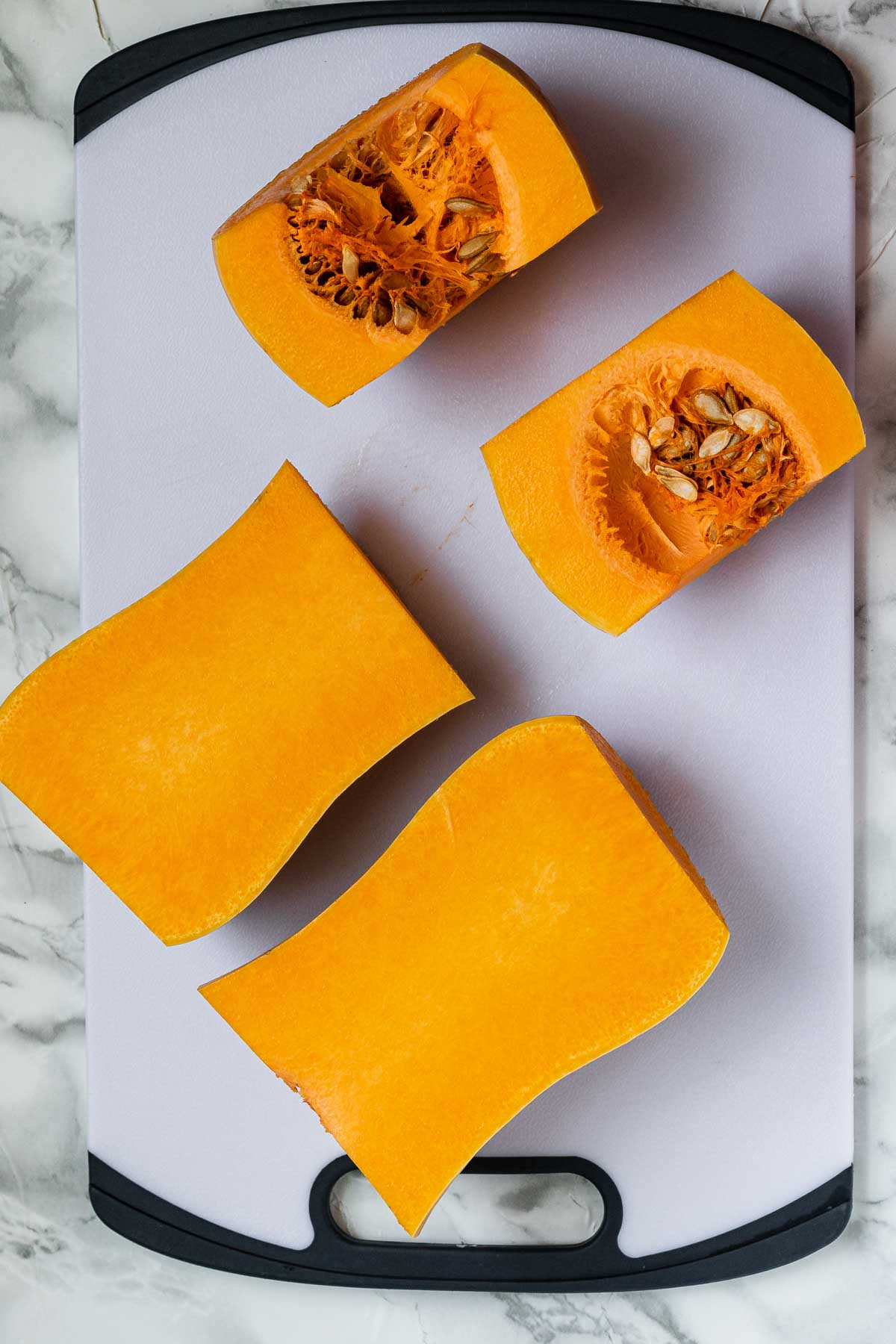 Butternut squash pieces on a cutting board.