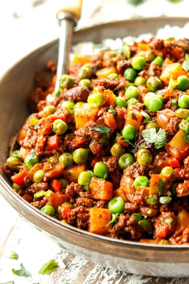 A close-up of a serving spoon in a bowl of Mexican Picadillo, ready to be served